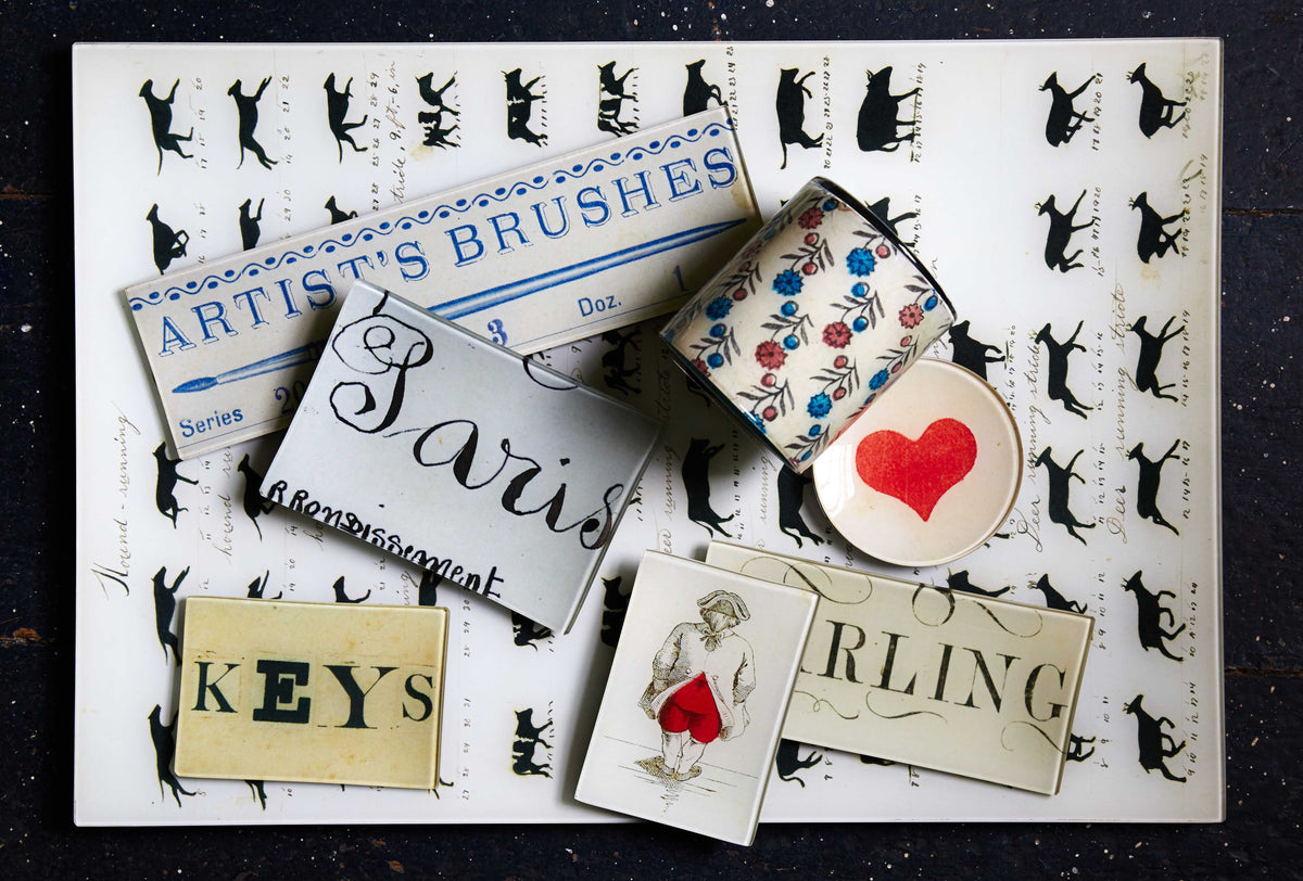 Glass decoupage trays with fonts, patterns and ephemera on a table