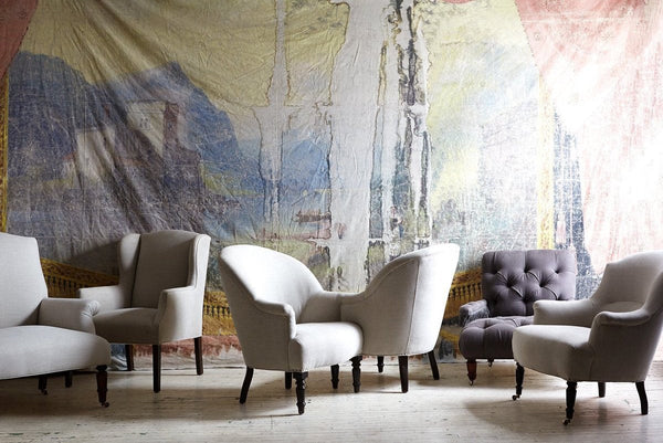 Group of Cisco Brother chairs in a row in front of a painted canvas