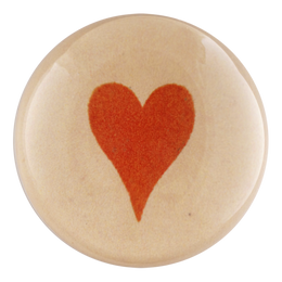 Dome paperweight that 3 inches by 1 inch with a red heart in the center.