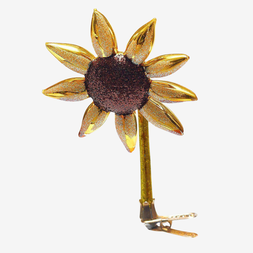 A gold-toned metal sunflower hair clip with a dark brown glittery center and a gold metal spring clip at the stem base, shown on a plain light gray background.