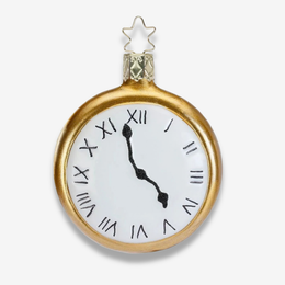 A gold-finished clock-shaped ornament with a white face, black Roman numerals, and black hands, topped with a small gold star.