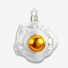 A novelty Christmas ornament shaped like a fried egg, featuring a glossy white outer yolk shell and a shiny gold center, with a gold hanging loop and star topper, shown on a light gray background.