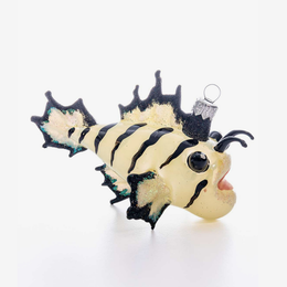 A decorative fish-shaped ornament with a cream body, bold black stripes, and black fins, shown on a plain white background. It has a small silver hanging loop at the top.