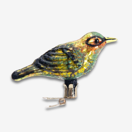 A vintage-style bird ornament with a metallic iridescent finish in green, gold, and black, mounted on a small metal stand against a light gray background.