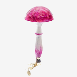 A decorative mushroom-shaped ornament with a glittery pink cap, a white stem with pink tips, and a gold fairy charm hanging from the base, shown against a plain white background.