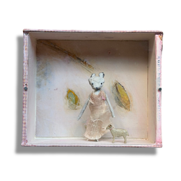 A handcrafted miniature diorama assemblage inside a distressed pink and white painted cigar box, featuring a small white mouse figurine in a textured dress standing next to a tiny white dog, set against a neutral white background.