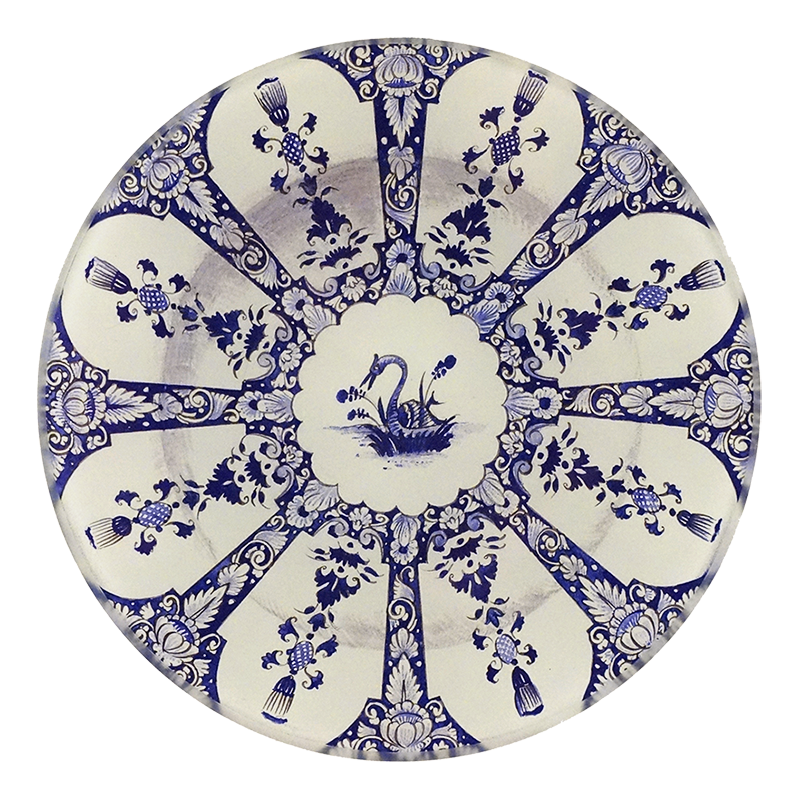A five inch round glass plate featuring a blue and white motif with a swan in the center
