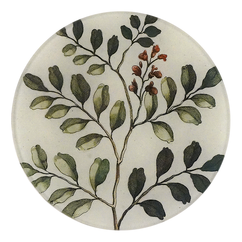 A five inch round glass plate with a handblown glass design featuring green and brown foliage and red berries