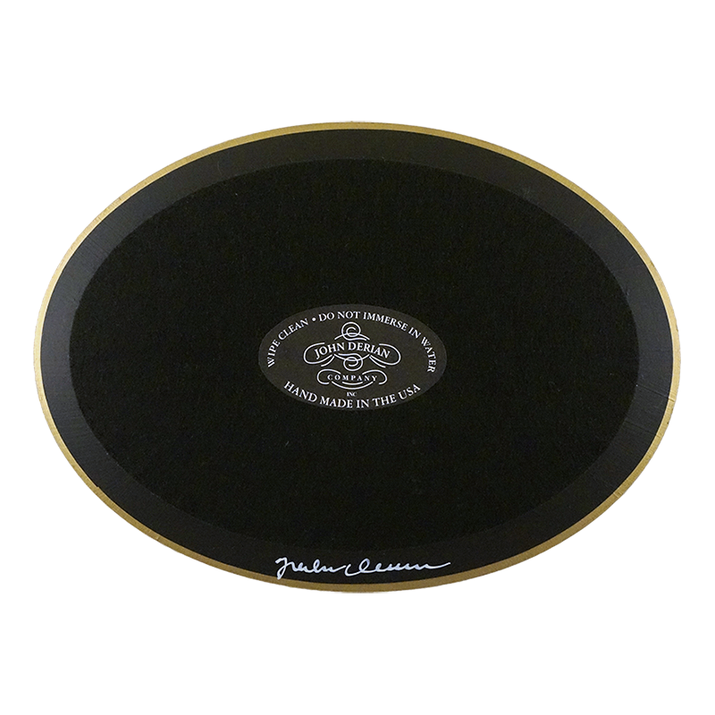 The back of a horizontal 5 inch by 7 inch oval-shaped plate painted black with black felt backing and gold trim. Featuring the John Derian Company sticker and signed by John Derian. 