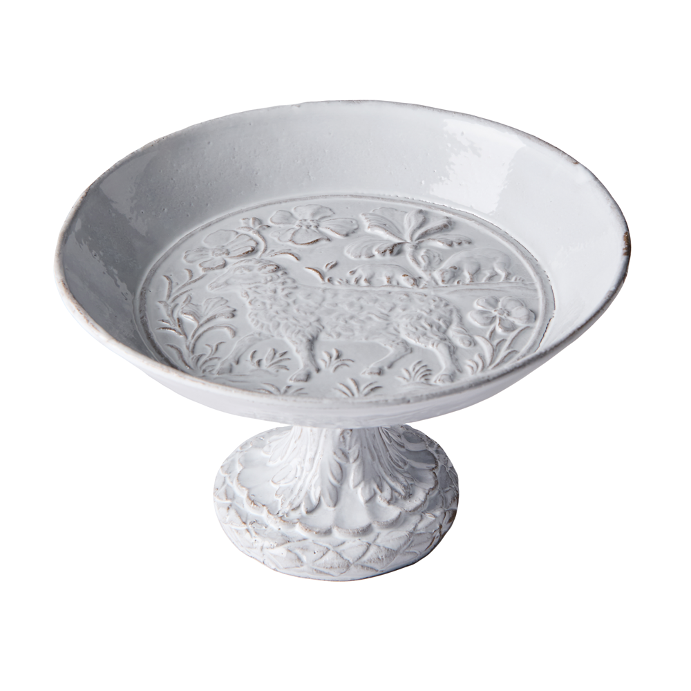 A white ceramic pedestal plate with embossed floral and animal motifs on the inner surface, shown on a plain white background.