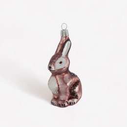A small glass rabbit ornament with a metallic rose-gold finish, white chest, and dark accents, shown on a plain white background.