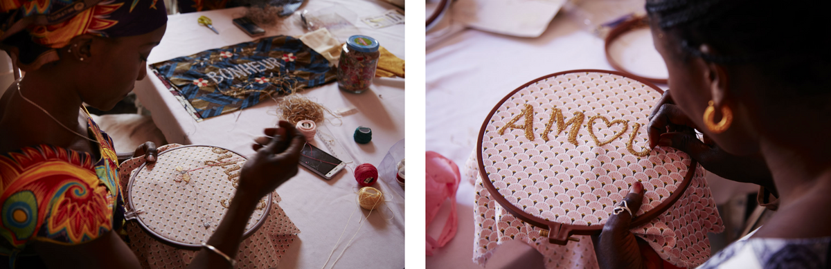A close-up women embroidering letters onto colorful fabrics using thread and embroidery loops.