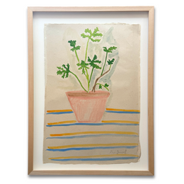 A framed watercolor painting of a potted green plant on a striped surface, presented in a light wood frame with a white mat against a white background.
