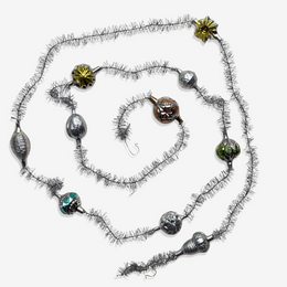Holiday garland coiled into a circle made of silver twine and mini glass classic baubles.