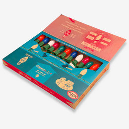 Open vintage-style Tinsley LED Christmas bulb box showing multicolored plastic bulbs inside a teal and red package on a light gray background.