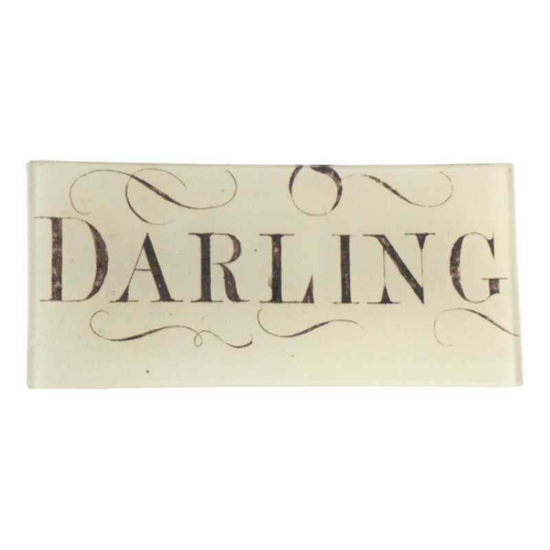 The text 'DARLING' written in a decorative font, predominantly in a black & white on a three and a half inch by seven inch glass tray.