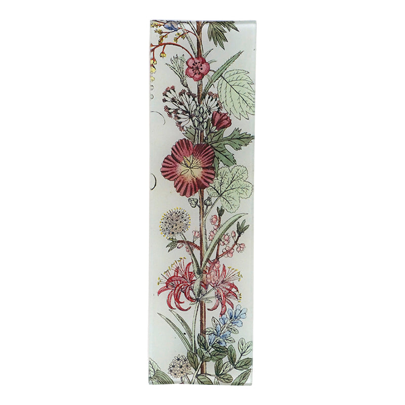 A floral design with prominent red geraniums on a three and a half inch by twelve inch glass tray. 