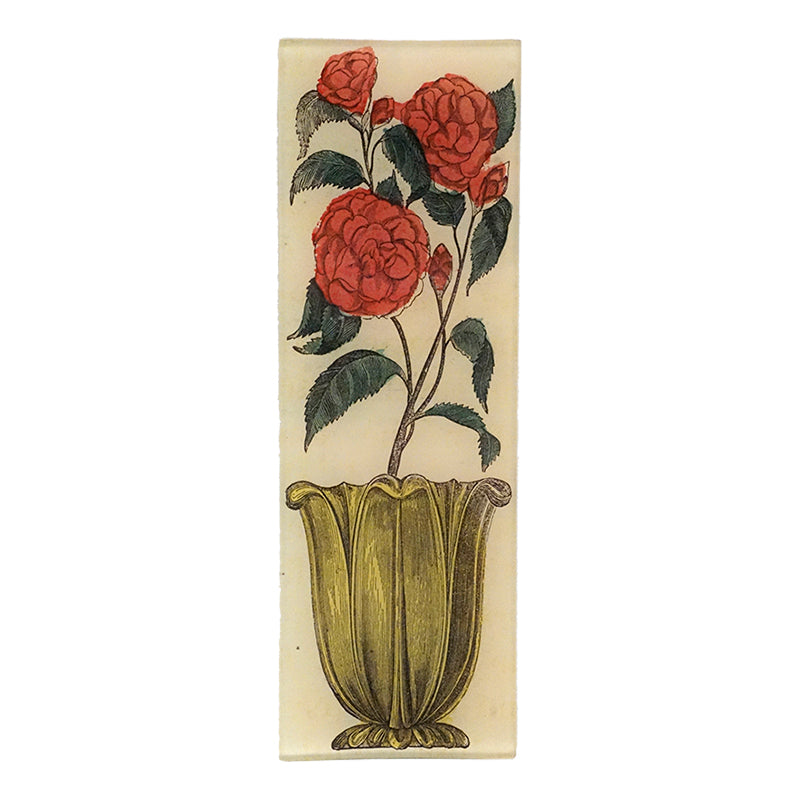 A red floral design in an antique vase on a four and a half inch by nine inch glass tray. 