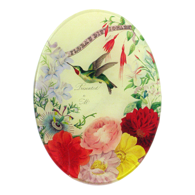 A five inch by seven inch vertical oval glass plate of a hummingbird surrounded by floral designs. 