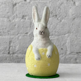 Papier-mache glitter rabbit in egg on table