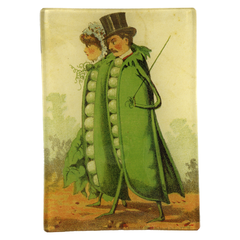 A man and woman with peas on their body named Two Peas in a Pod on a four and a half inch by six and a half inch glass tray.