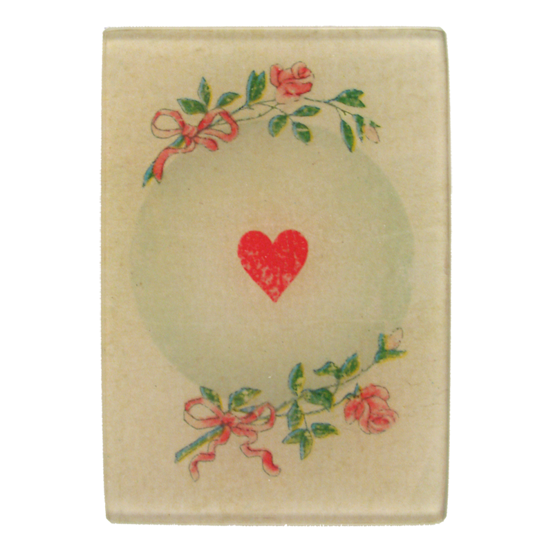 A red heart and floral motifs on a three and a half inch by five inch glass tray. 